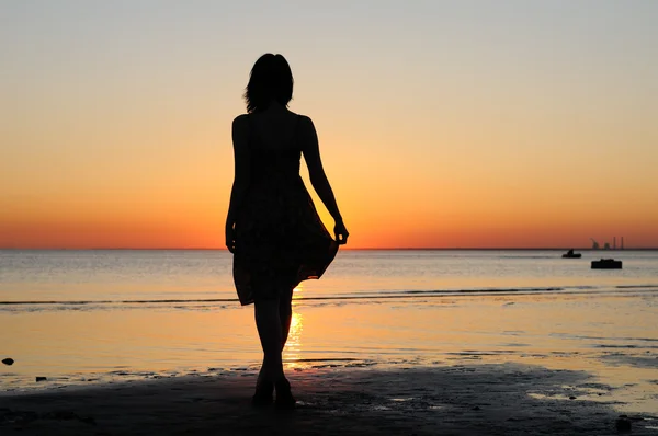 Young woman as silhouette by the sea