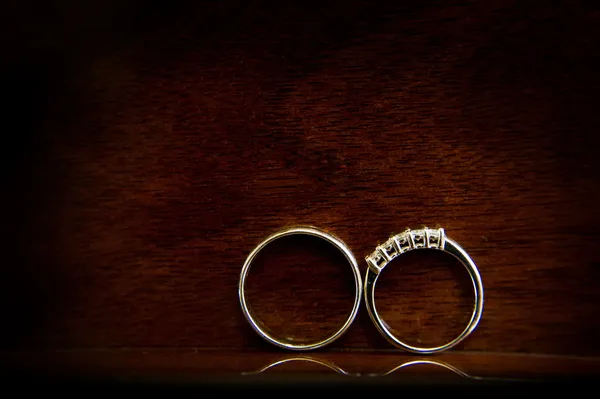 Wedding bands / wedding rings on dark wood background