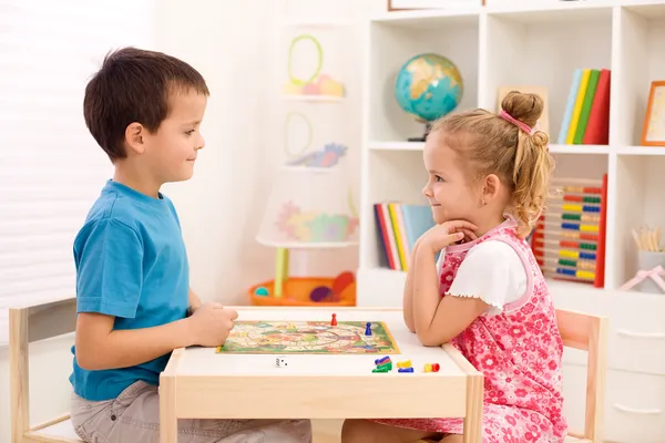 Kids playing board game in their room