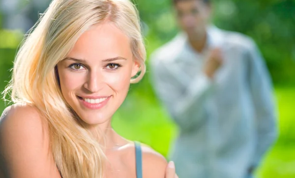 Young beautiful woman and looking at woman man on background
