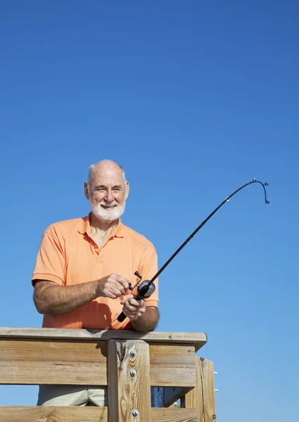 Senior Man Reels in Fish Vertical