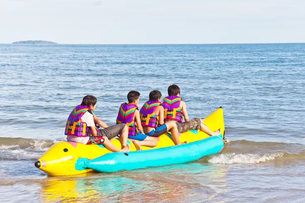 Group of young riding banana boat