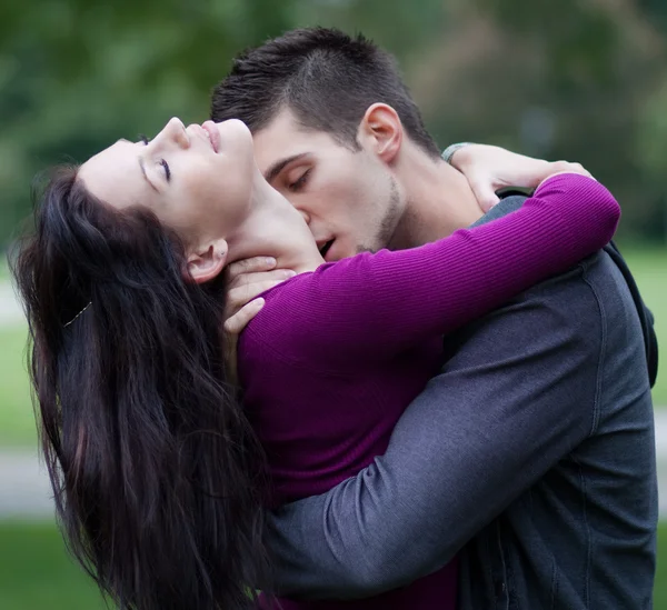 Young man passionately kissing his girlfriend on the neck