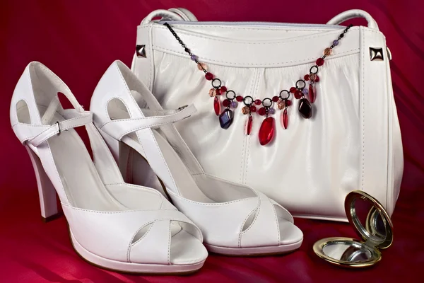 White high-heeled shoes and handbag with necklace