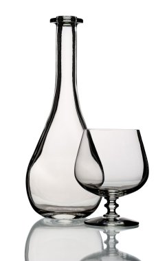 Glass bottle and goblet, isolated.