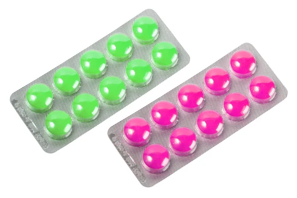 Два металевих блістера з фіолетовими і зеленими таблетками — стокове фото