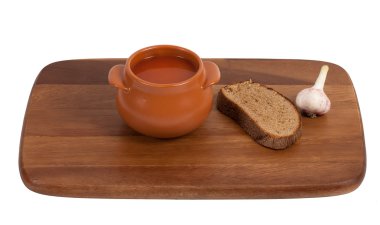 Soup in clay pot on wooden kitchen board clipart
