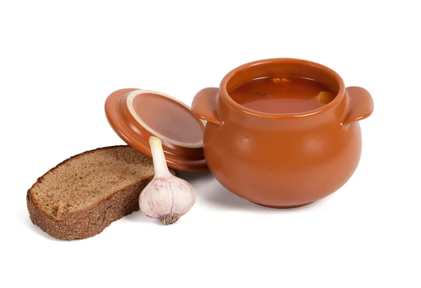 stock image Borsch in clay pot with bread and garlic