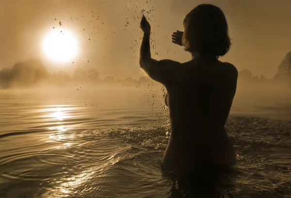 Vrouw spetteren in water — Stockfoto