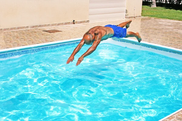 Hombre saltando a la piscina — Foto de Stock