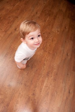 Boy stands on parquet clipart