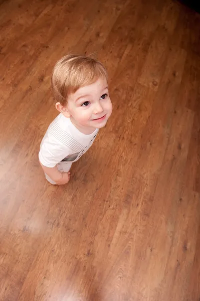 男孩站在木地板上 — 图库照片