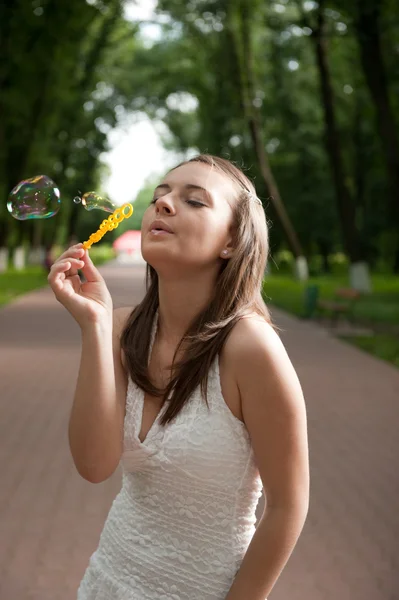 Jong meisje waait bubbels — Stockfoto