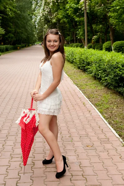 Молодая девушка с зонтиком в парке — стоковое фото