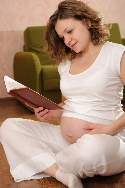 Mujer embarazada lectura libro — Foto de Stock