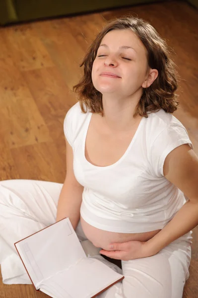 Беременная женщина читает книгу — стоковое фото