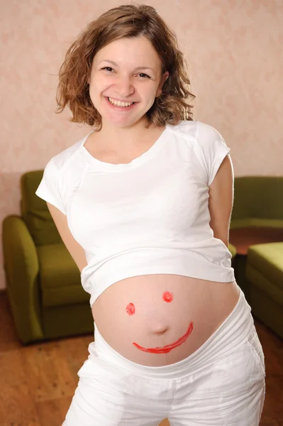 Úsměv se znaménkem na těhotné si břicho — Stock fotografie