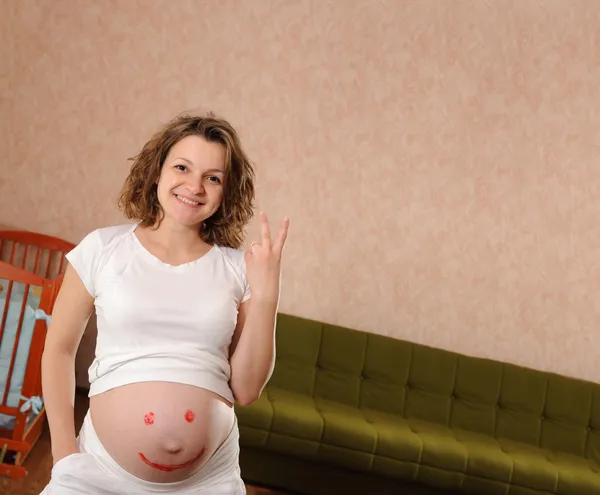 Giovane incinta con segno sorriso dipinto — Foto Stock