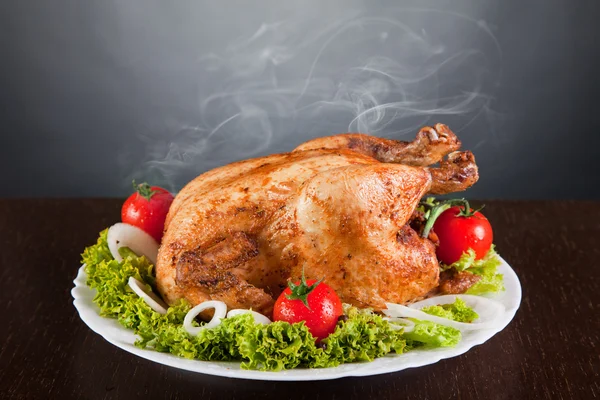 Вкусная жареная курица с красными помидорами и зеленым салатом — стоковое фото