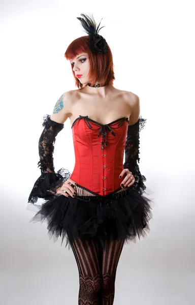 Mulher atraente em espartilho vermelho e saia preta — Fotografia de Stock