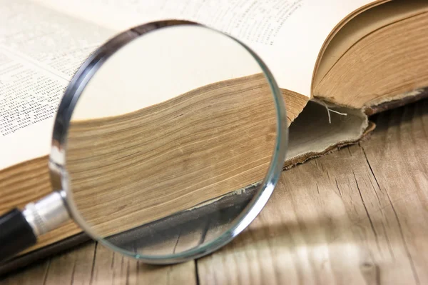 Old book and magnifying glass
