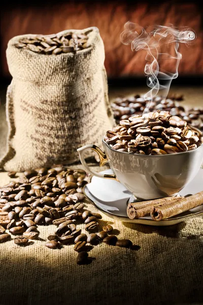 Granos de café en taza y saco —  Fotos de Stock