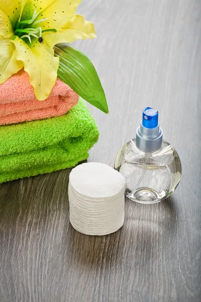 Láhev ručník květ a vatové tampony na dřevěné pozadí — Stock fotografie