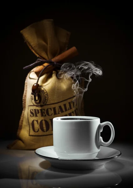 Sammensætning af hvid kop og sæk kaffebønner - Stock-foto