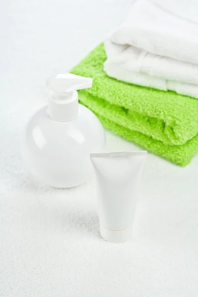Bílá lahev trubice a ručníky — Stock fotografie