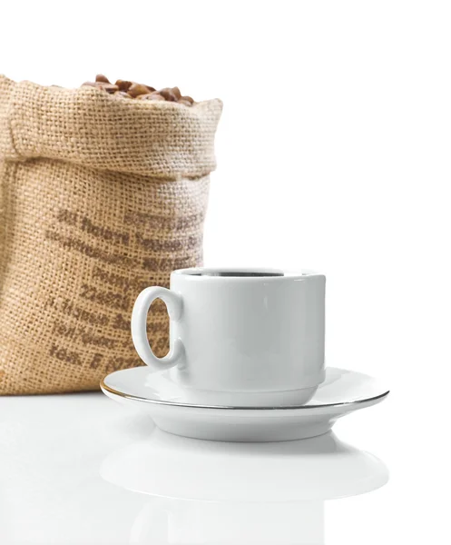 White cup and sack with beans — Stock Photo, Image