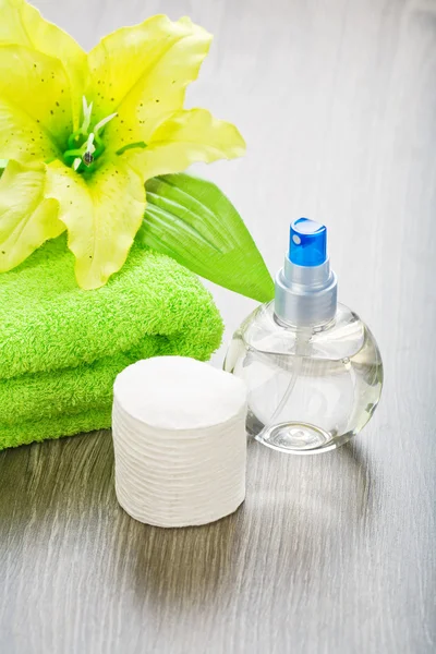 Transparante fles handdoek bloem en katoen pads — Stockfoto