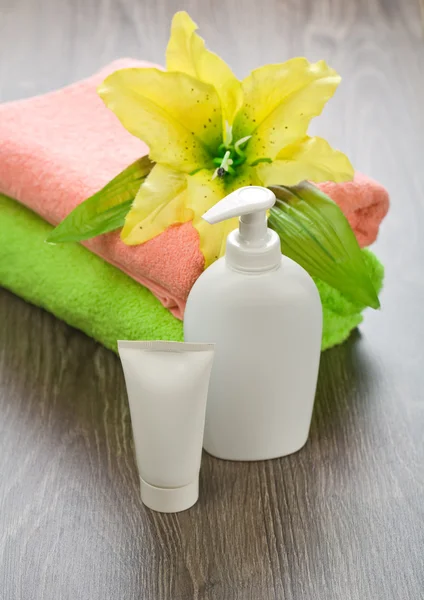Flor em toalhas com tubo e garrafa — Fotografia de Stock