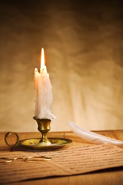 Burning candle and music sheet — Stock Photo, Image