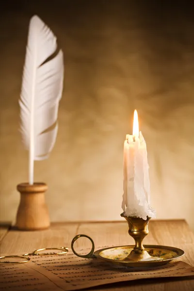 Bodegón romántico con vela encendida y hoja de música —  Fotos de Stock