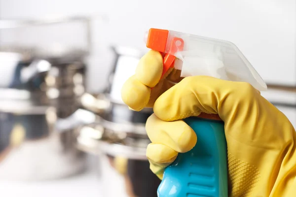Вручите защитную перчатку, удерживая спрей. уборка кухонного гардероба — стоковое фото