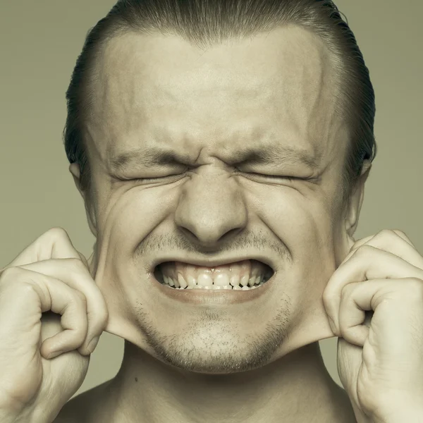 Retrato de um homem estendendo suas bochechas — Fotografia de Stock