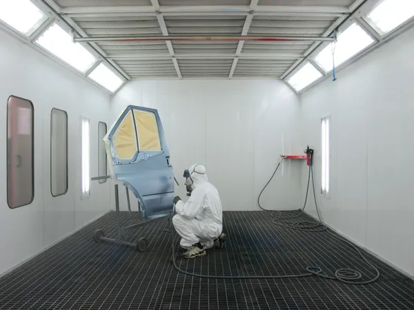 Pintor trabaja en una cabina de pulverización — Foto de Stock