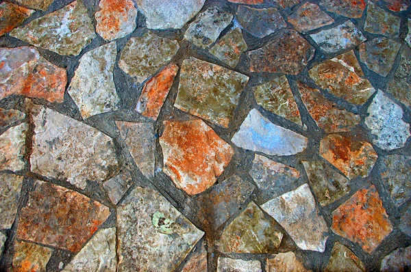 Achtergrond detail van leeftijd en kleurrijke stenen muur — Stockfoto