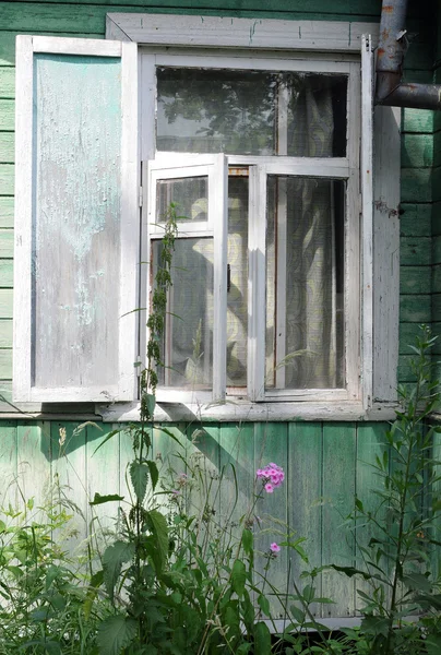 Offenes Fenster eines schäbigen Landhauses — Stockfoto