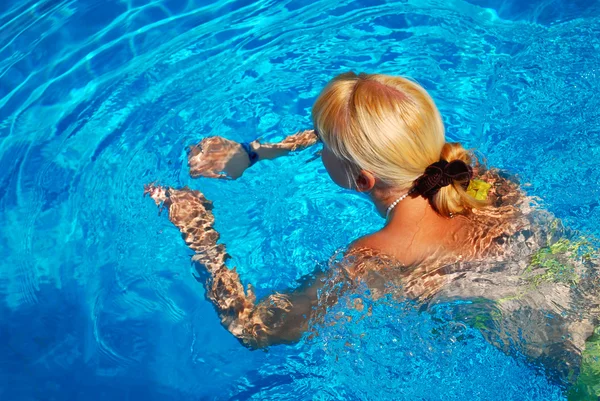 Unga vuxna flicka simma i poolen Royaltyfria Stockfoton