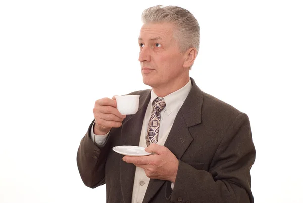 Empresario bebiendo de una taza sobre un fondo blanco —  Fotos de Stock