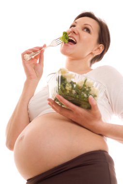 Hamile kadın salata yiyor.