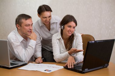 Group of employees in the office with laptops clipart