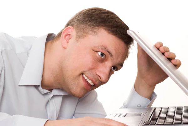 Νεαρός άνδρας εξετάζει ένα φορητό υπολογιστή σε λευκό φόντο — Φωτογραφία Αρχείου