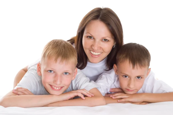 Usměvavá máma sedí u stolu s syny — Stock fotografie