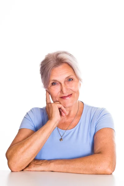 Mulher mais velha em azul em um branco — Fotografia de Stock