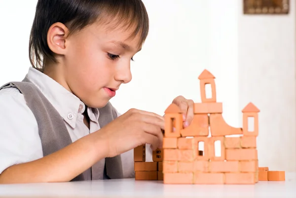 Красивий хлопчик будує іграшковий замок — стокове фото