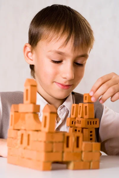 Menino bonito constrói um castelo de brinquedos — Fotografia de Stock