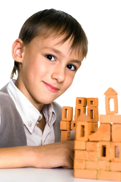 Knappe jongen bouwt een speelgoed-kasteel — Stockfoto