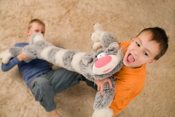 床におもちゃの猫を持つ 2 人の子供 — ストック写真